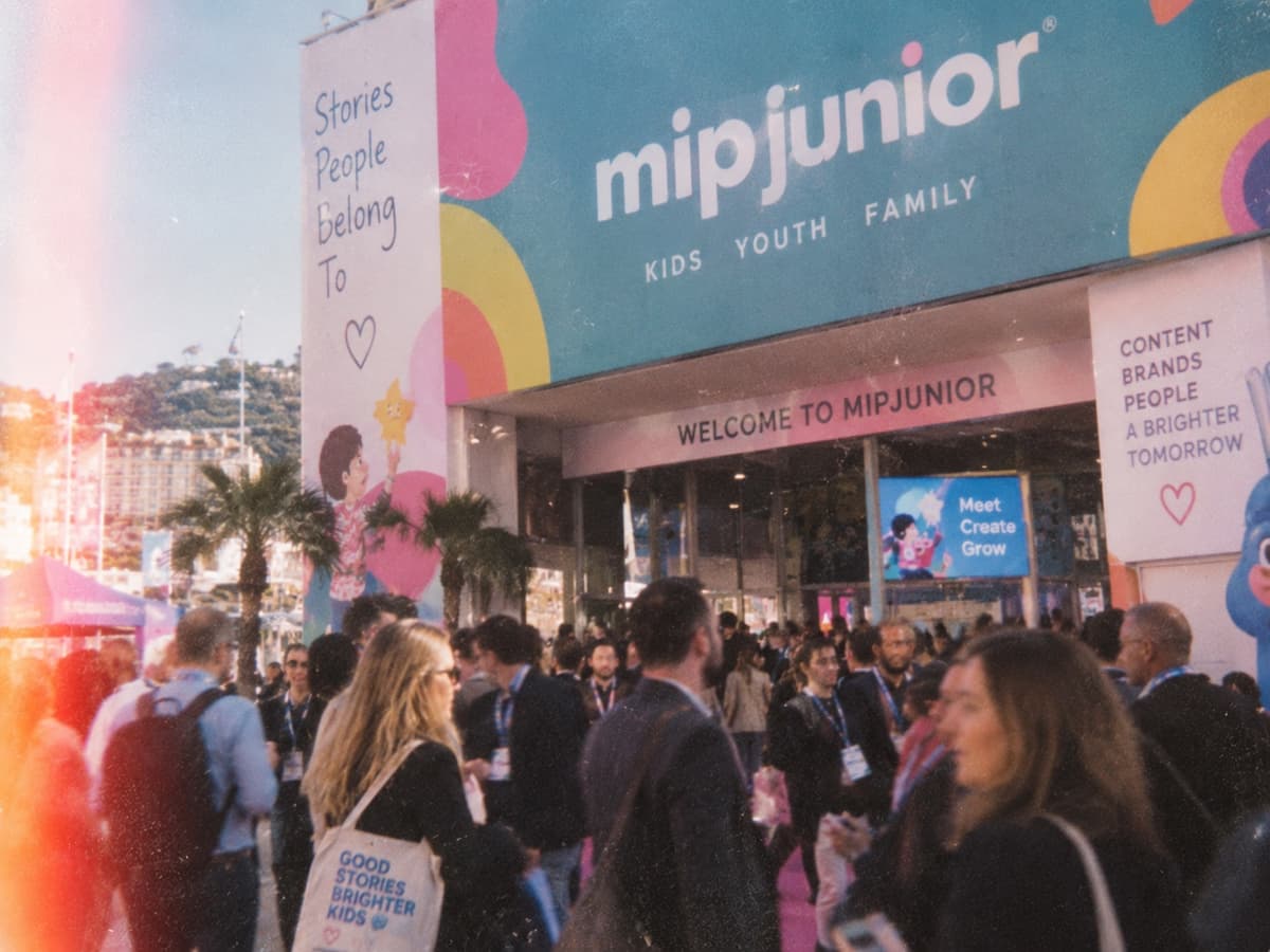 Crowds of industry visitors entering MIPJunior in Cannes under the market's welcome banner
